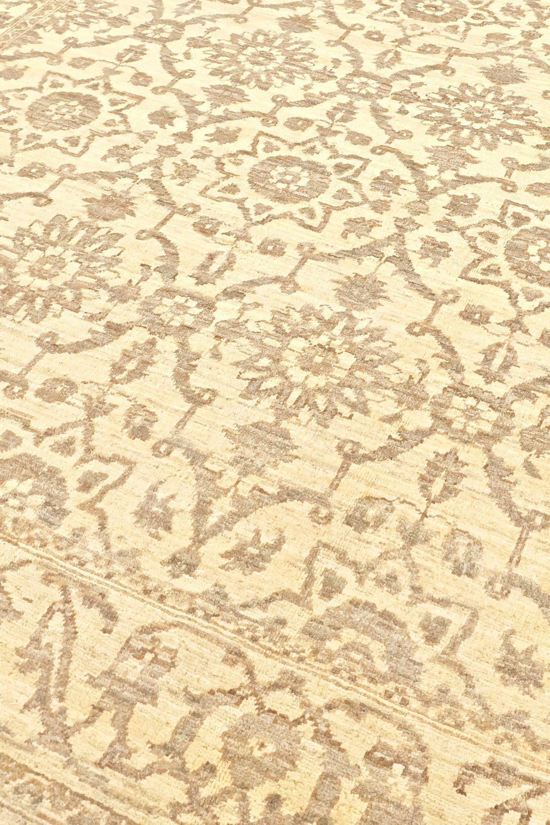 Close-up of a patterned rug with intricate designs on a beige background