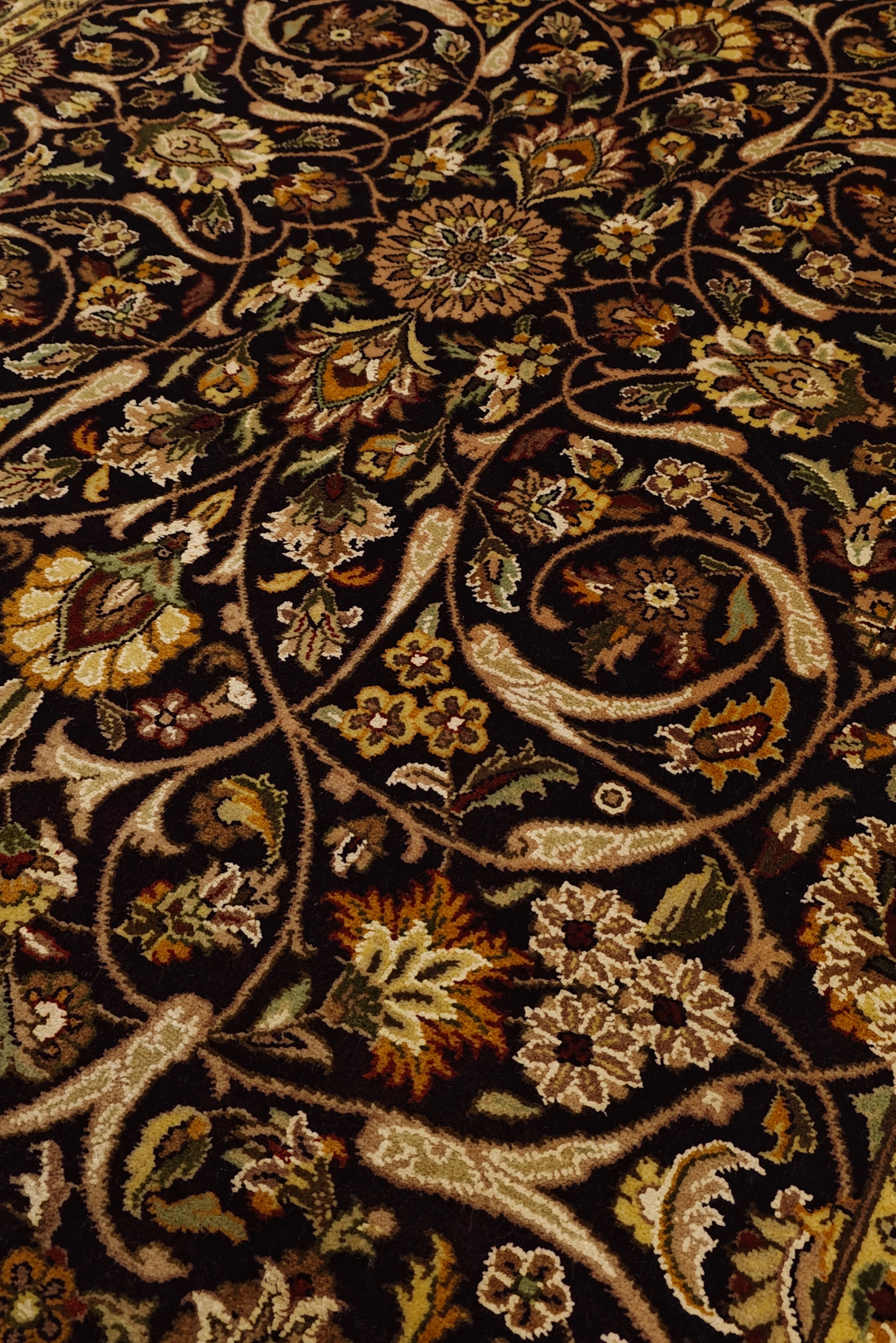 Close-up of an intricately designed floral rug with brown and beige colors.