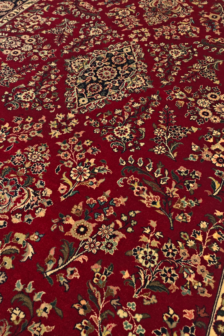 Close-up of a red patterned rug with intricate designs.
