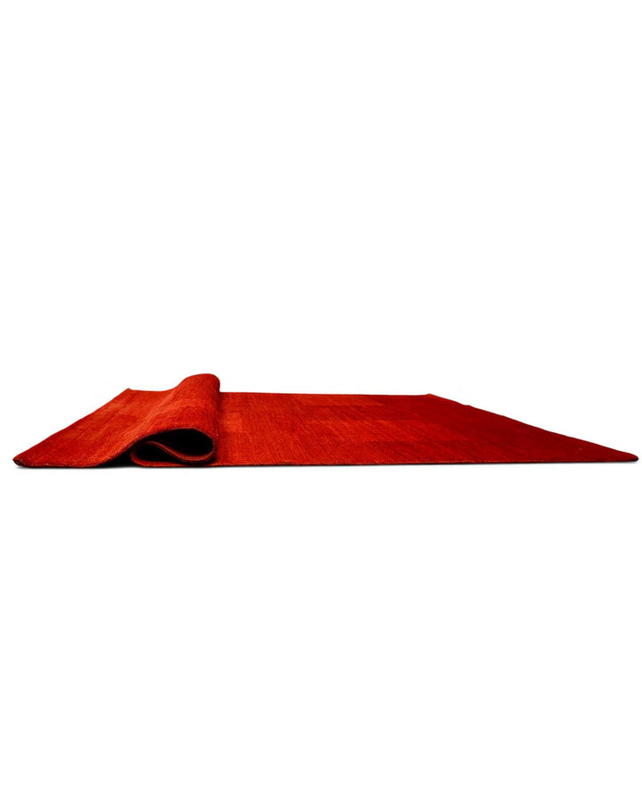 Corner of vermilion red Afghan Gabbeh wool rug
