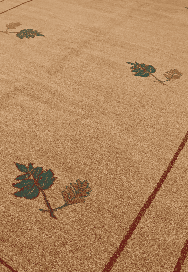 Floral sprig detail in camel and green on Ghazni rug