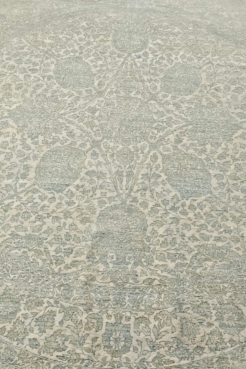 Concentric floral detail in sage and cream on round rug