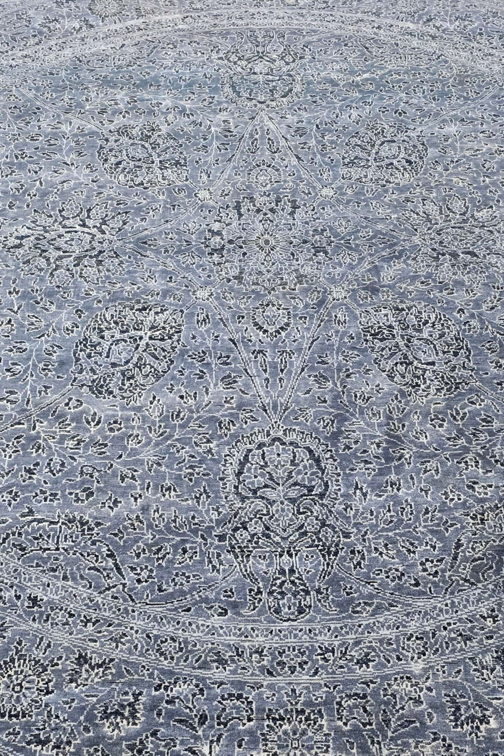 All-over floral detail in slate blue and silver on round rug