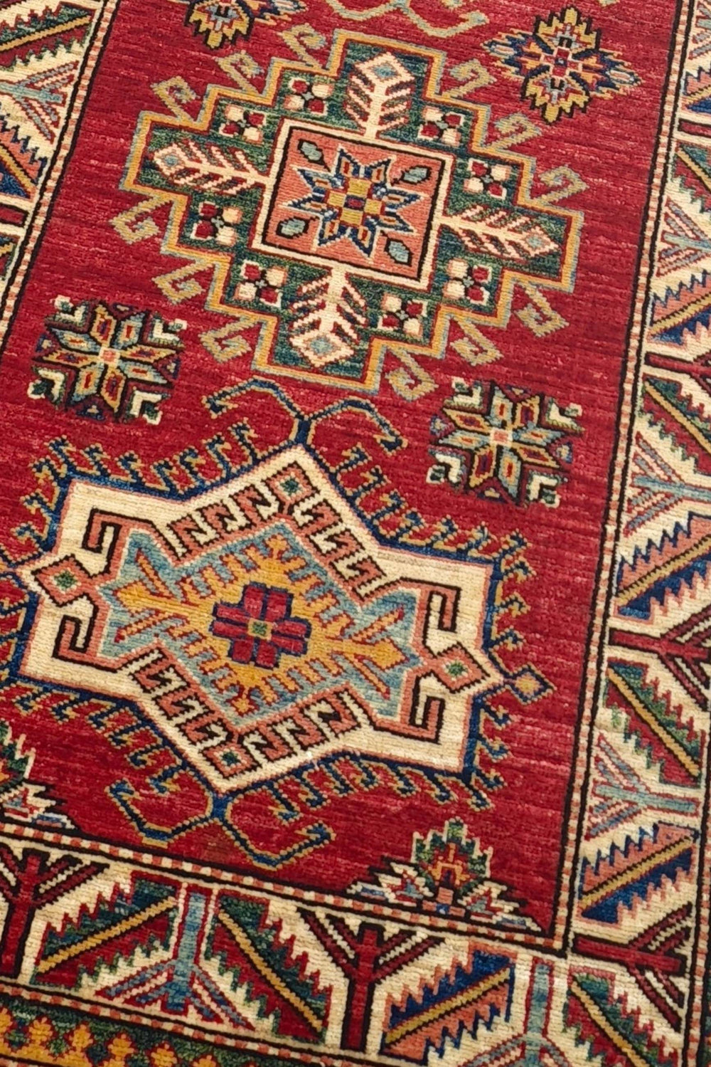 Stepped medallion detail in deep red and cream on Kazak runner