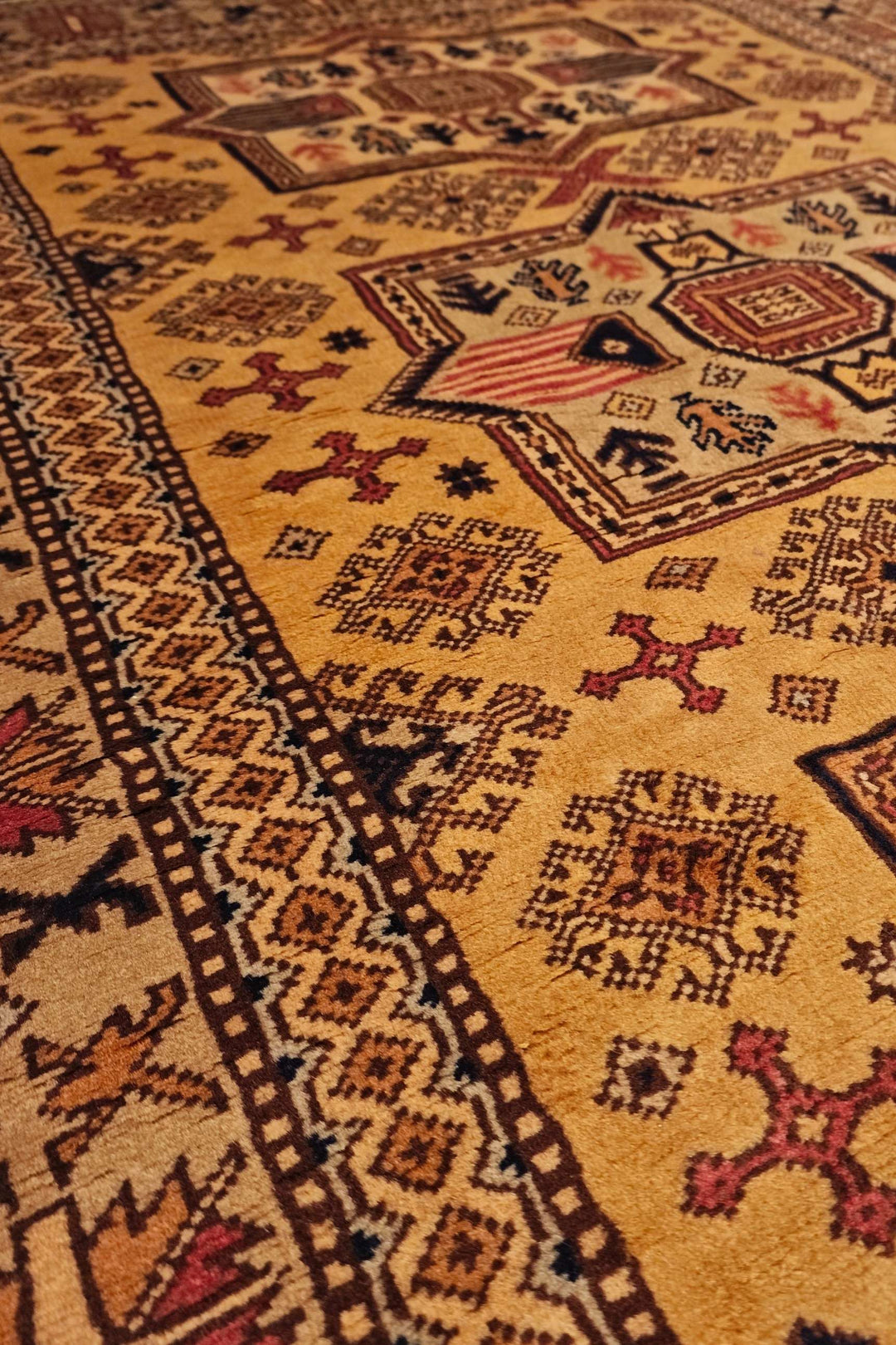 Star medallion detail in gold on Kazak rug