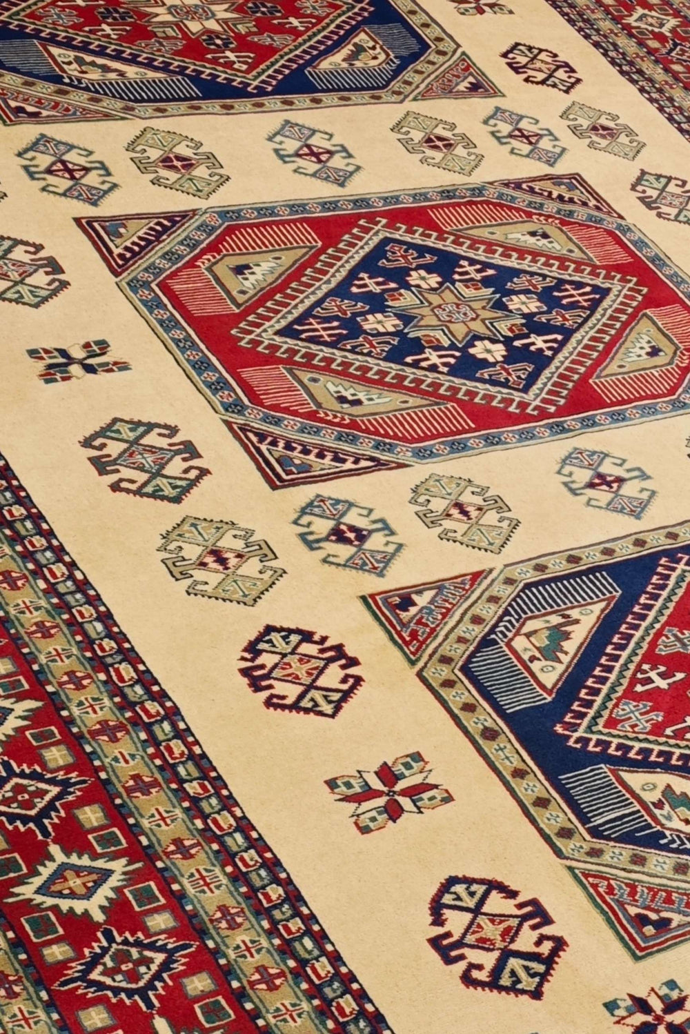 Kazak medallion detail in ivory and red on Afghan Sherwan rug