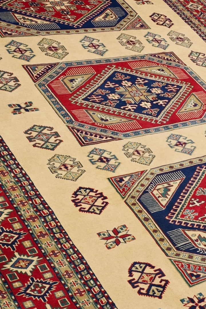 Kazak medallion detail in ivory and red on Afghan Sherwan rug
