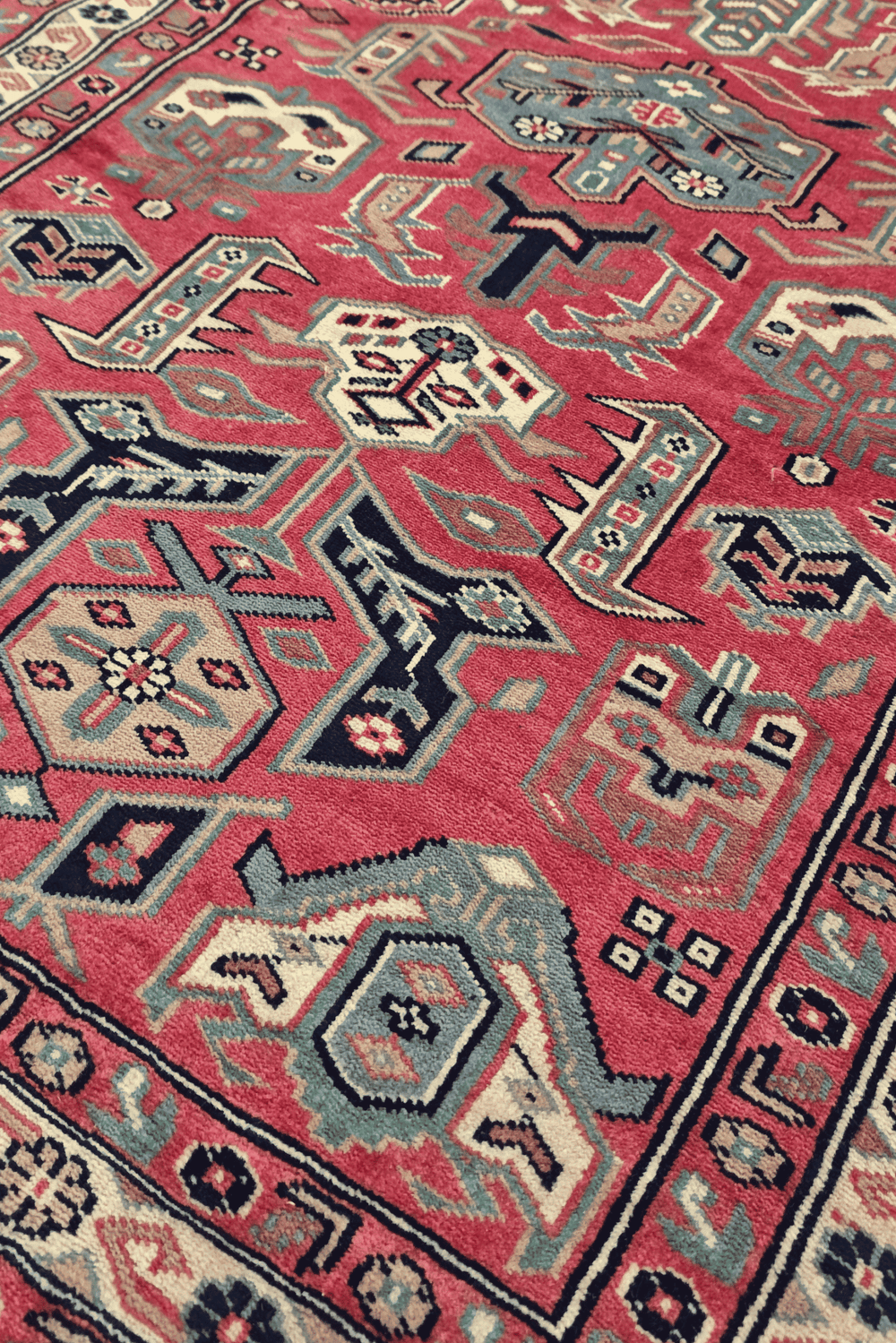 Serrated leaf medallion detail in rose and teal on Kazak runner