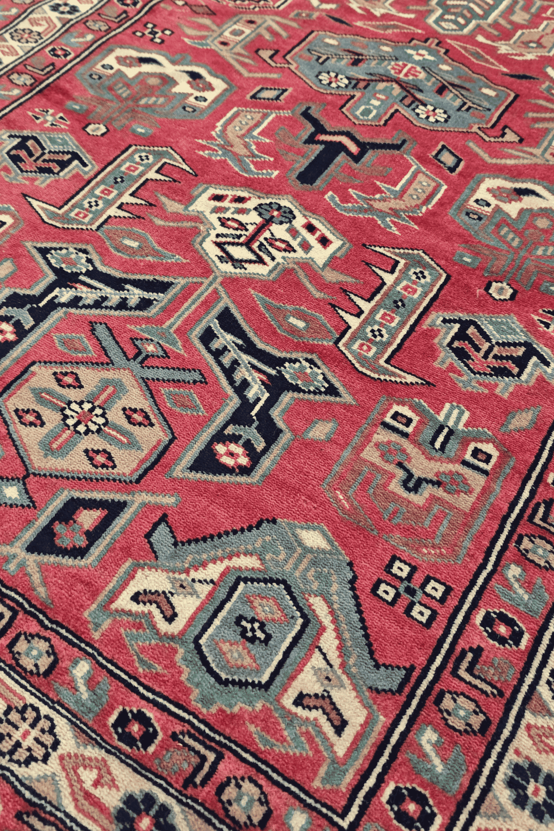 Serrated leaf medallion detail in rose and teal on Kazak runner