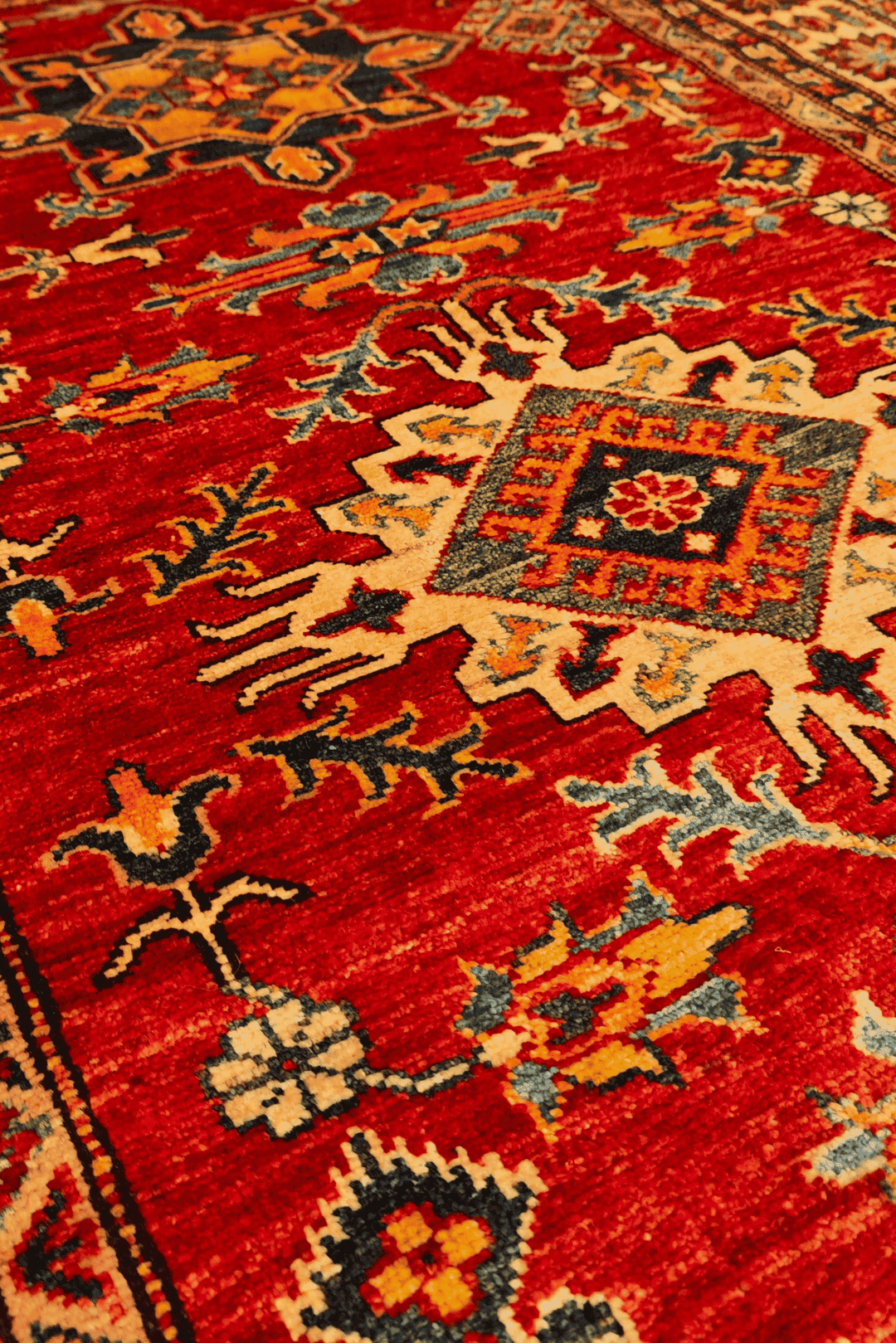 Border detail of red gold star Kazak rug