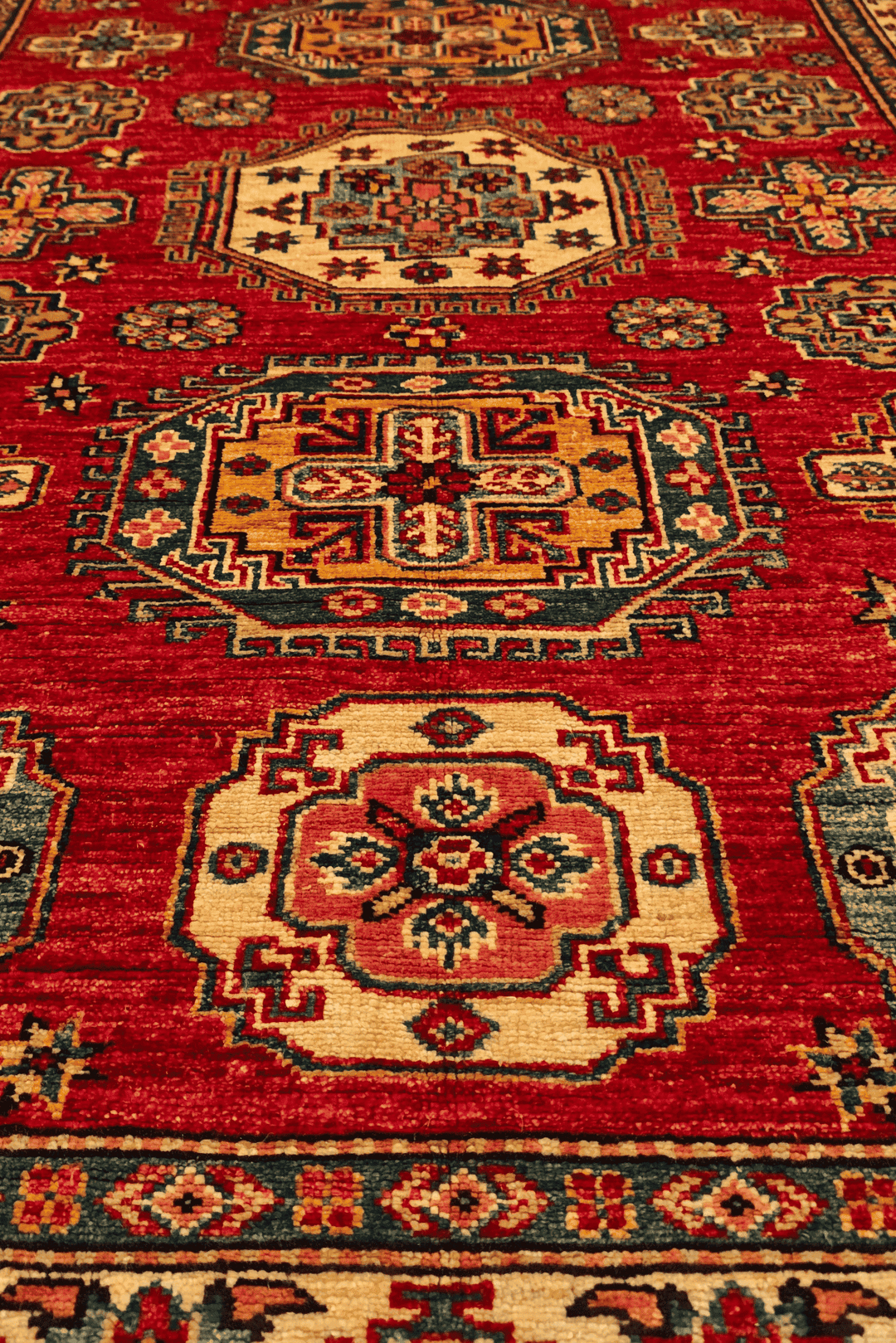 Border detail of red teal Kazak hand-knotted rug