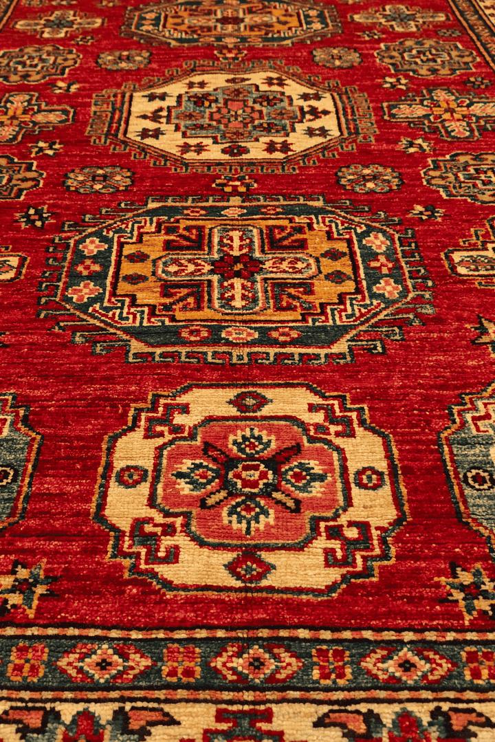 Border detail of red teal Kazak hand-knotted rug