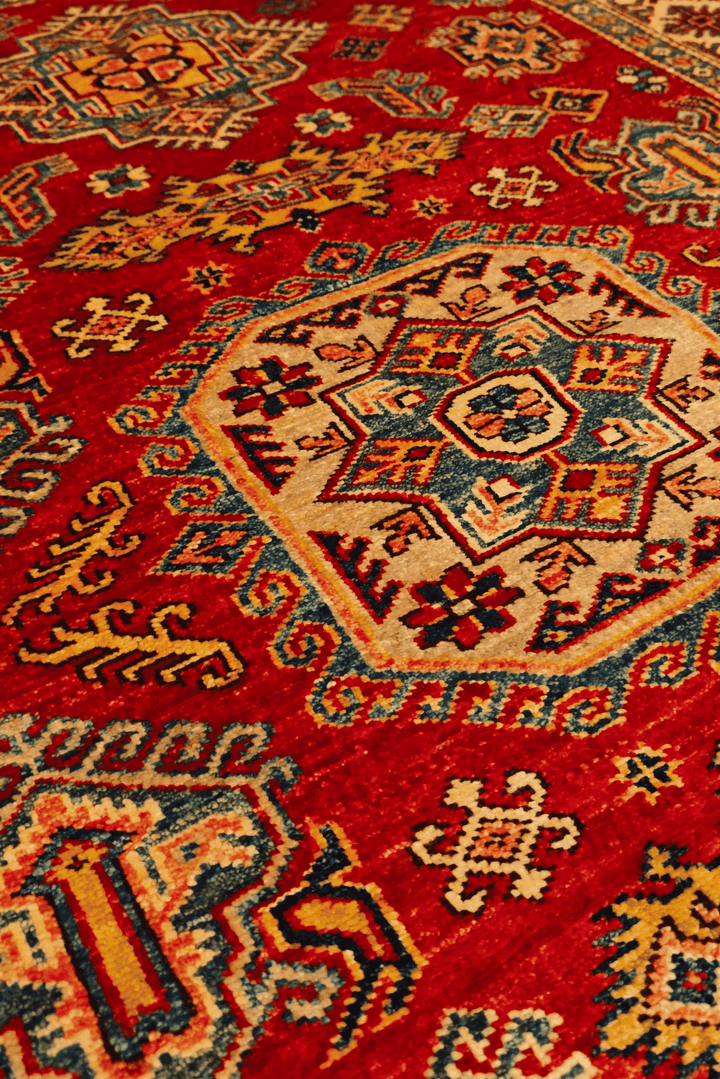Border detail of red gold gül Kazak rug