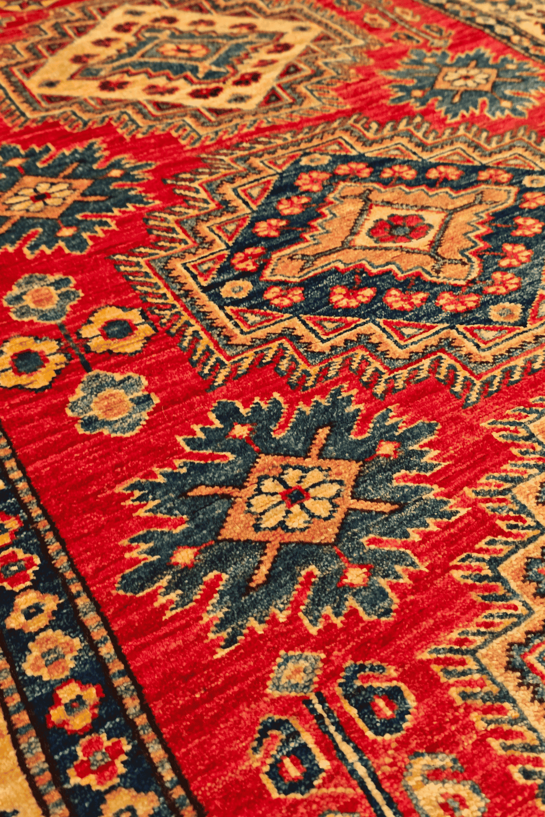 Border detail of red gold medallion Kazak rug
