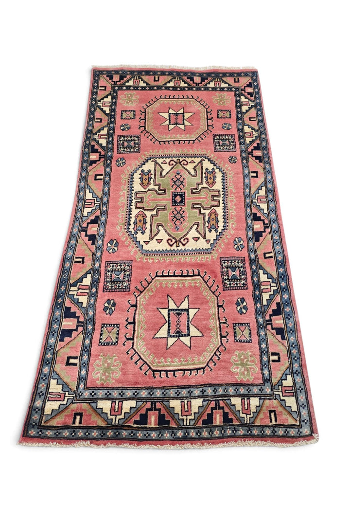Border detail of rose ivory Kazak hand-knotted rug