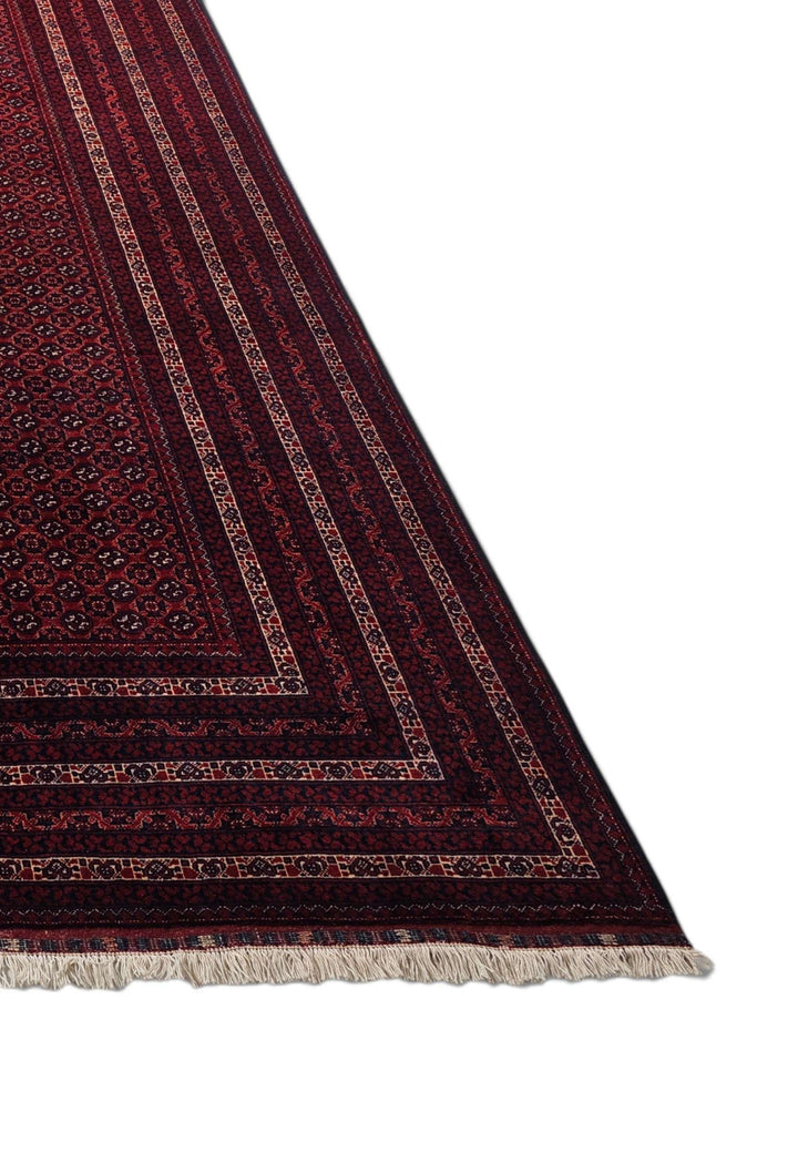 Corner of deep burgundy Khoja Roshnai hand-knotted Afghan rug