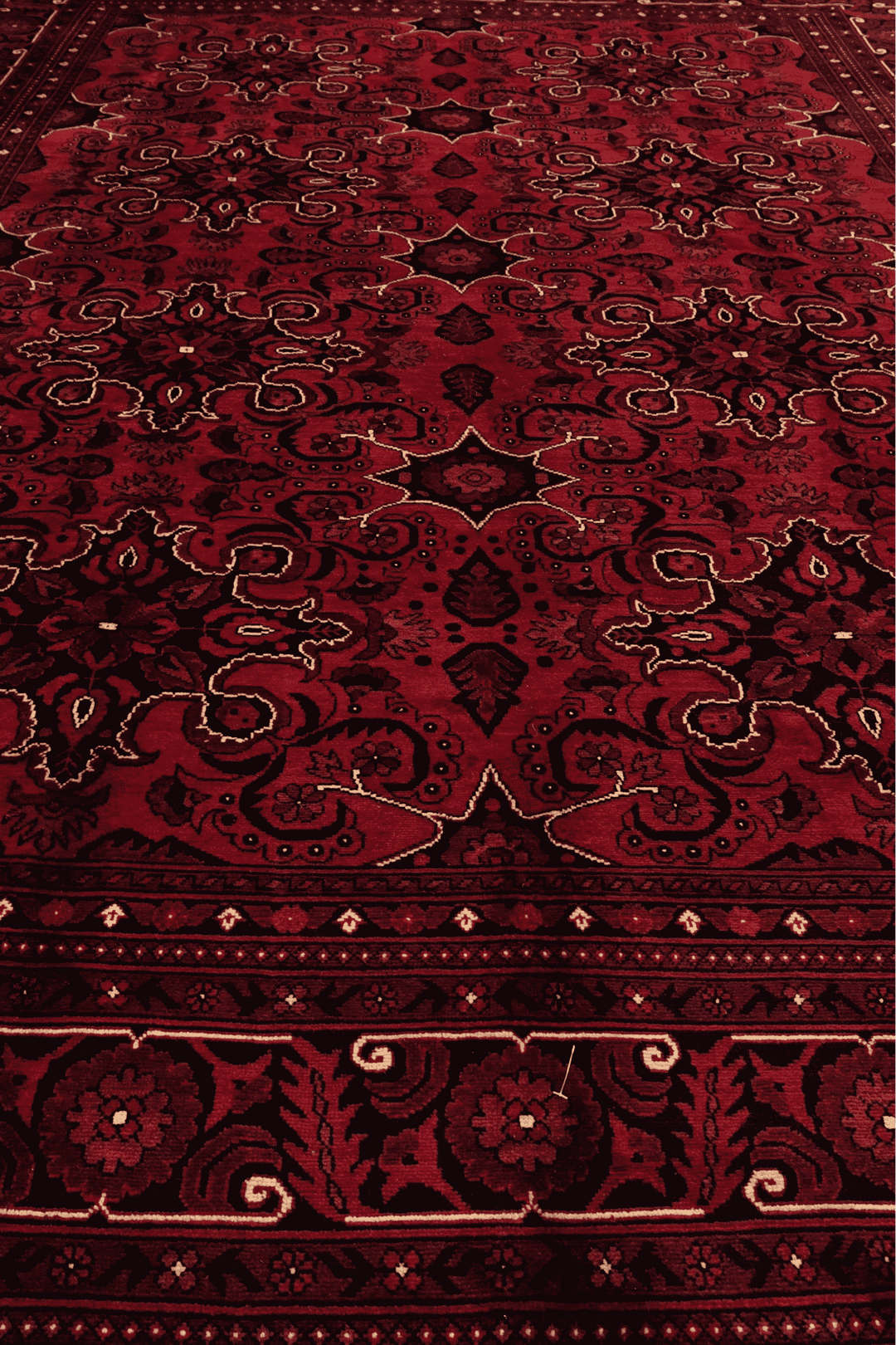 Corner of deep red cartouche hand-knotted rug