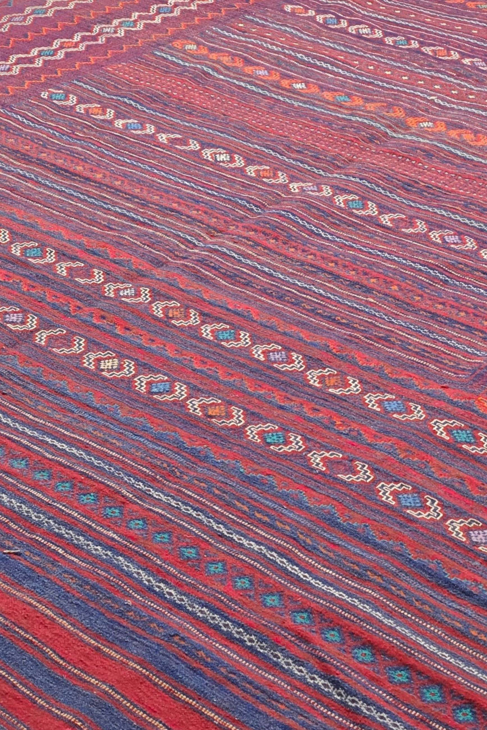 Pattern detail in rose red and plum on Afghan kilim