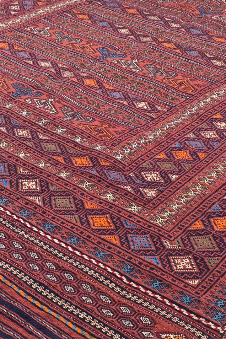 Banded detail in rose red and orange on Afghan kilim