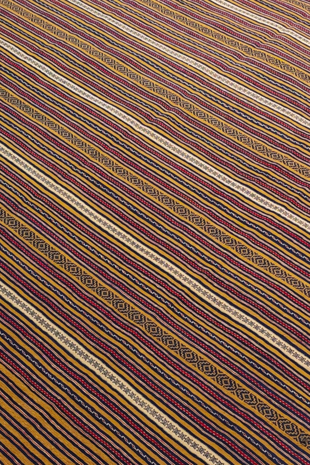 Stripe detail in gold and plum on Afghan kilim