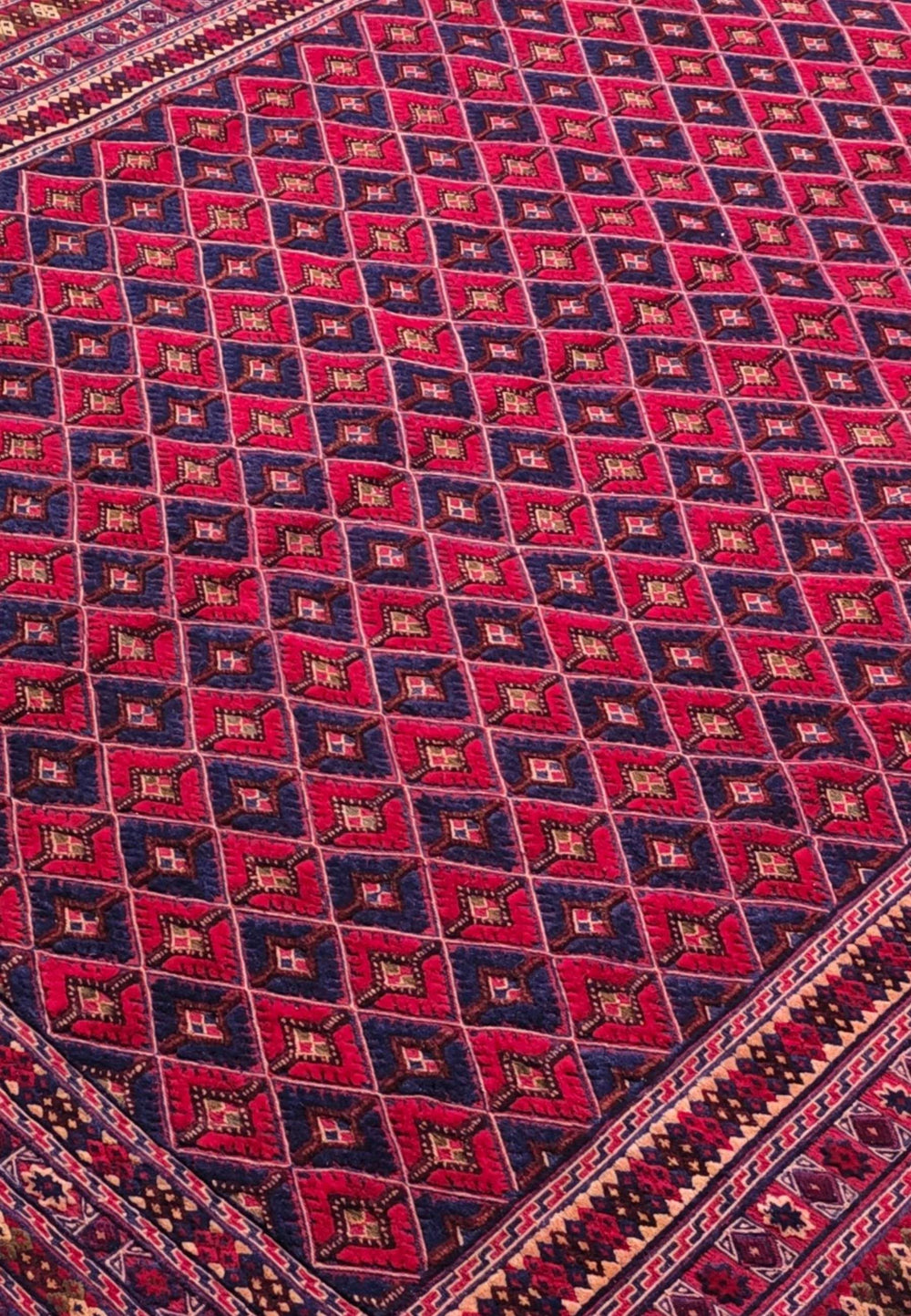 Diamond lattice detail in crimson and navy on Afghan kilim