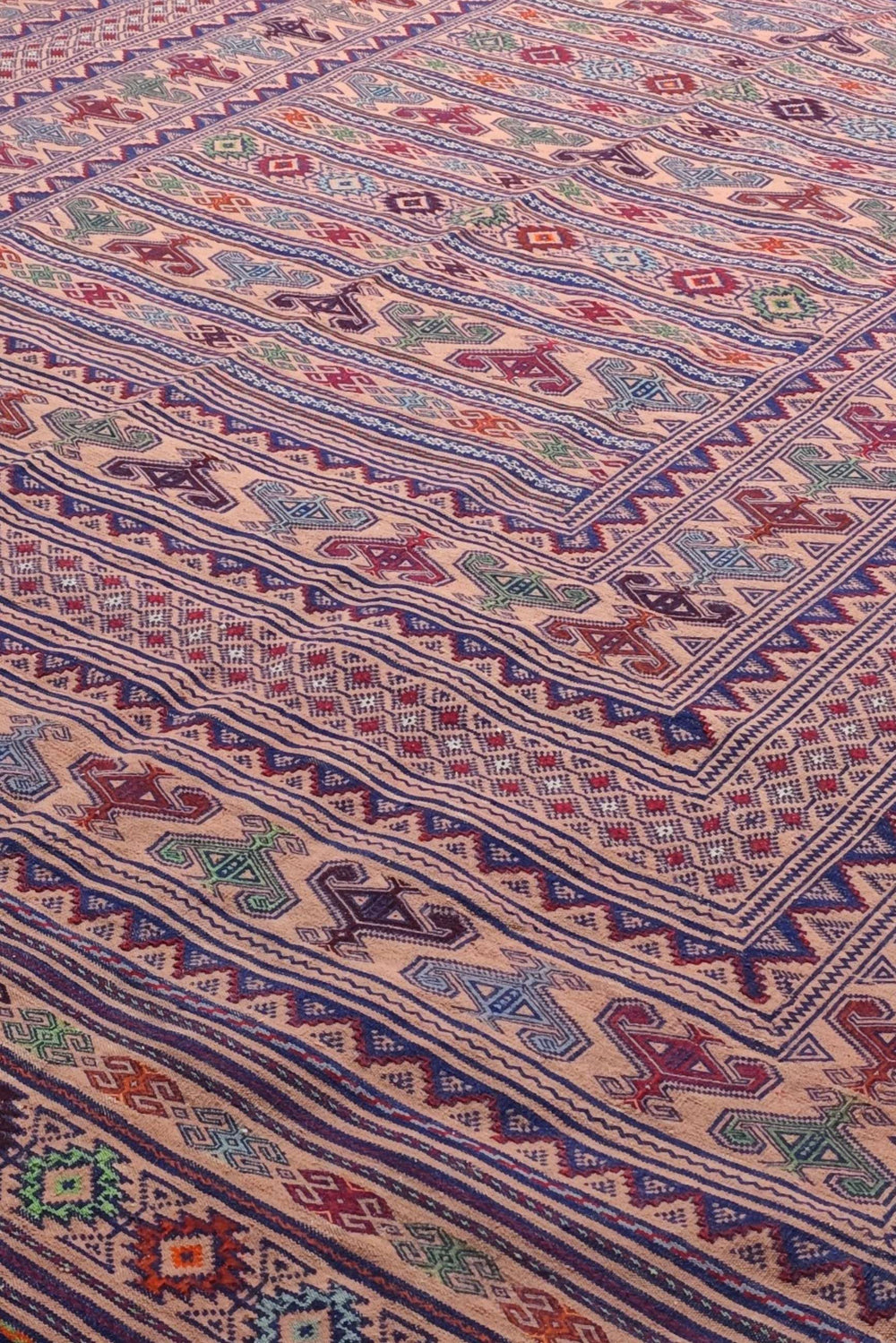 Banded detail in blush apricot and navy on Afghan kilim