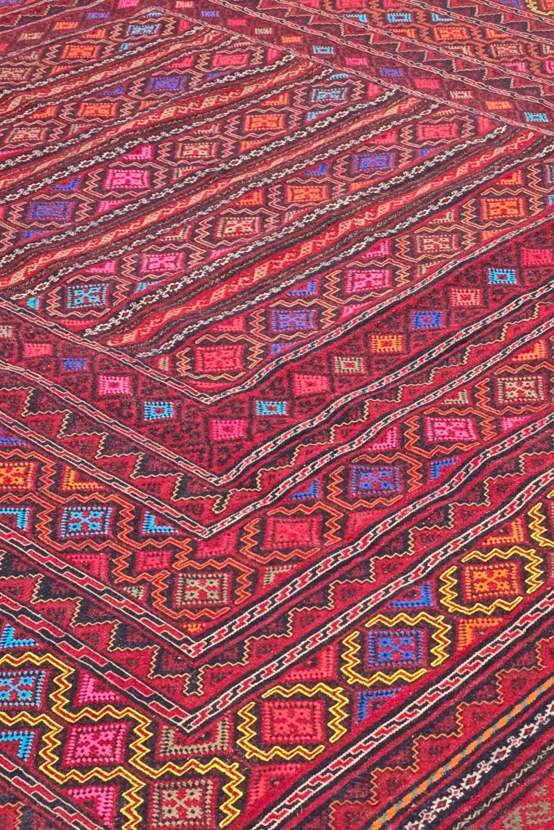 Banded detail in rose red and gold on Afghan kilim
