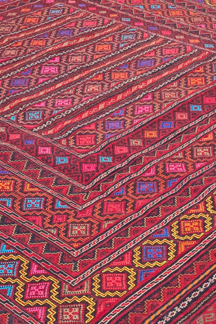 Banded detail in rose red and gold on Afghan kilim