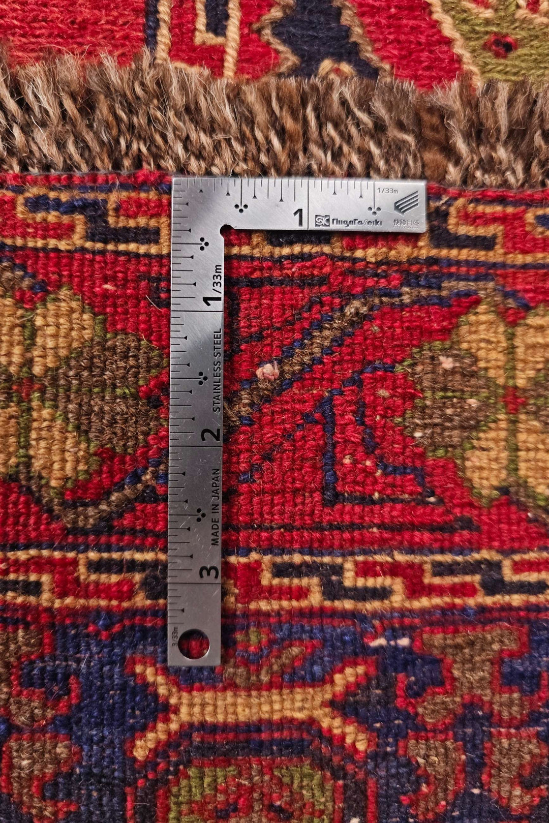 Corner of red and navy twin medallion kilim