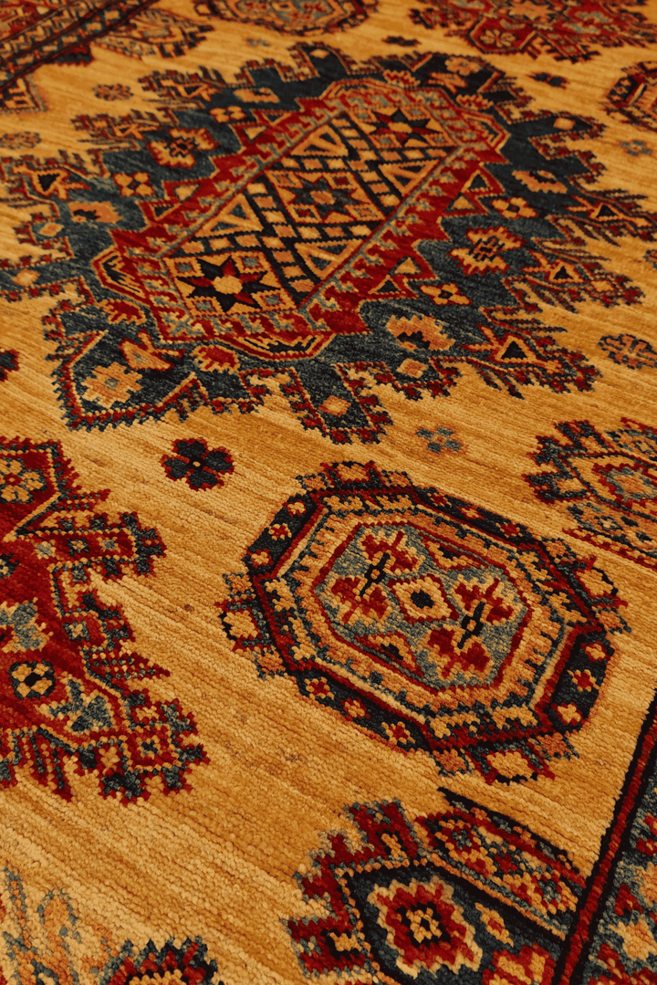 Border detail of gold and navy hand-knotted Afghan Sherwan rug