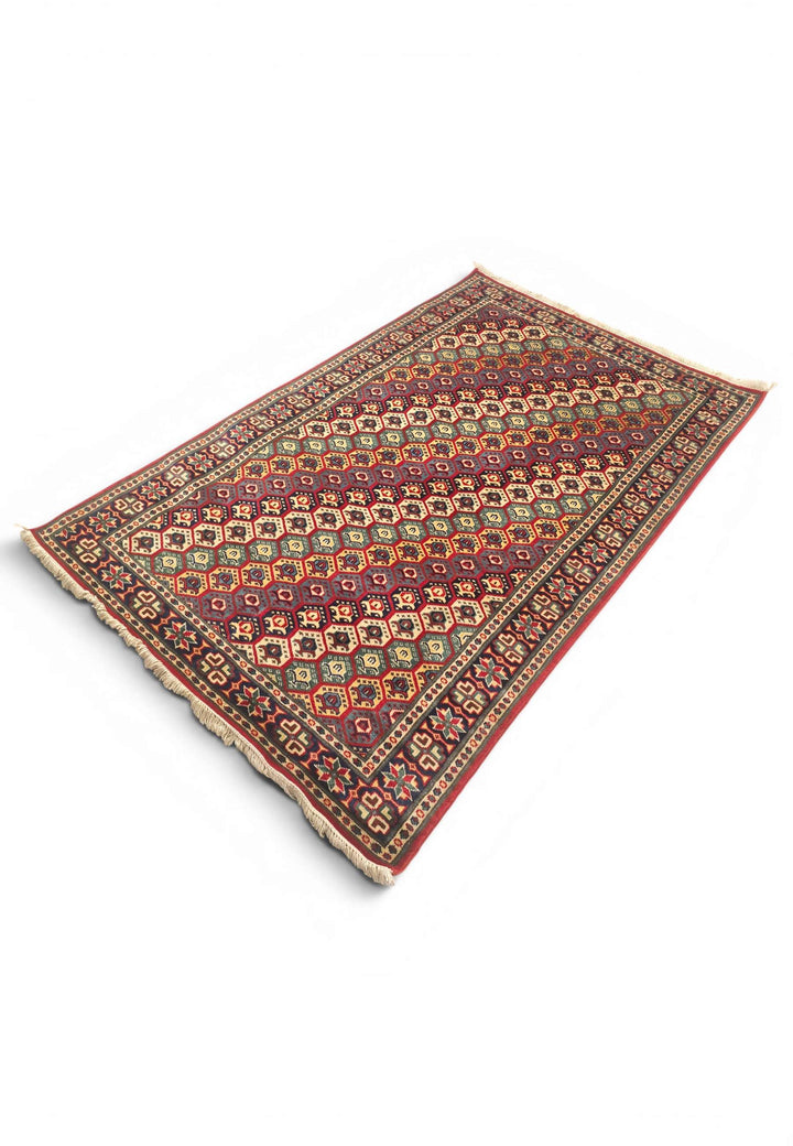 Border detail of multicolour honeycomb hand-knotted Afghan rug
