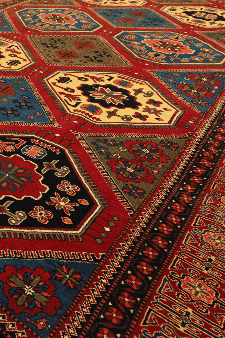 Border detail of burgundy and gold hand-knotted Afghan rug