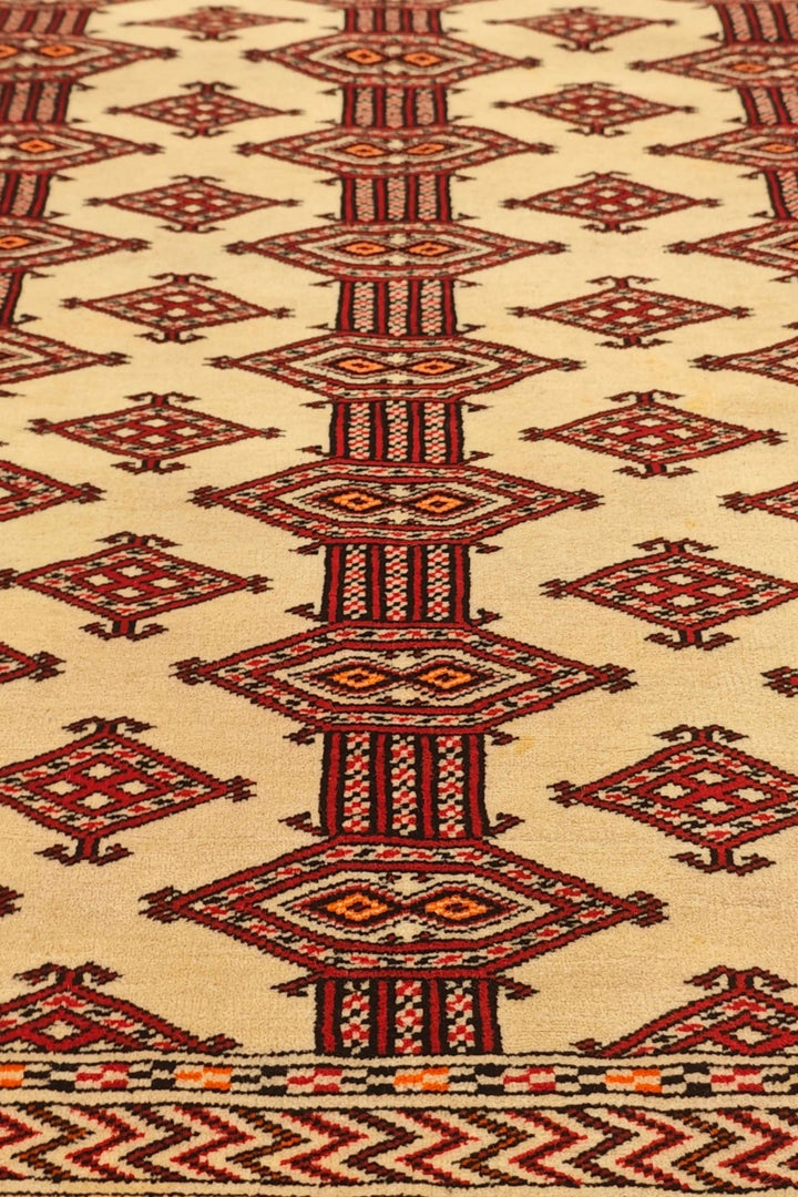 Border detail of ivory and red hand-knotted Afghan Sherwan rug