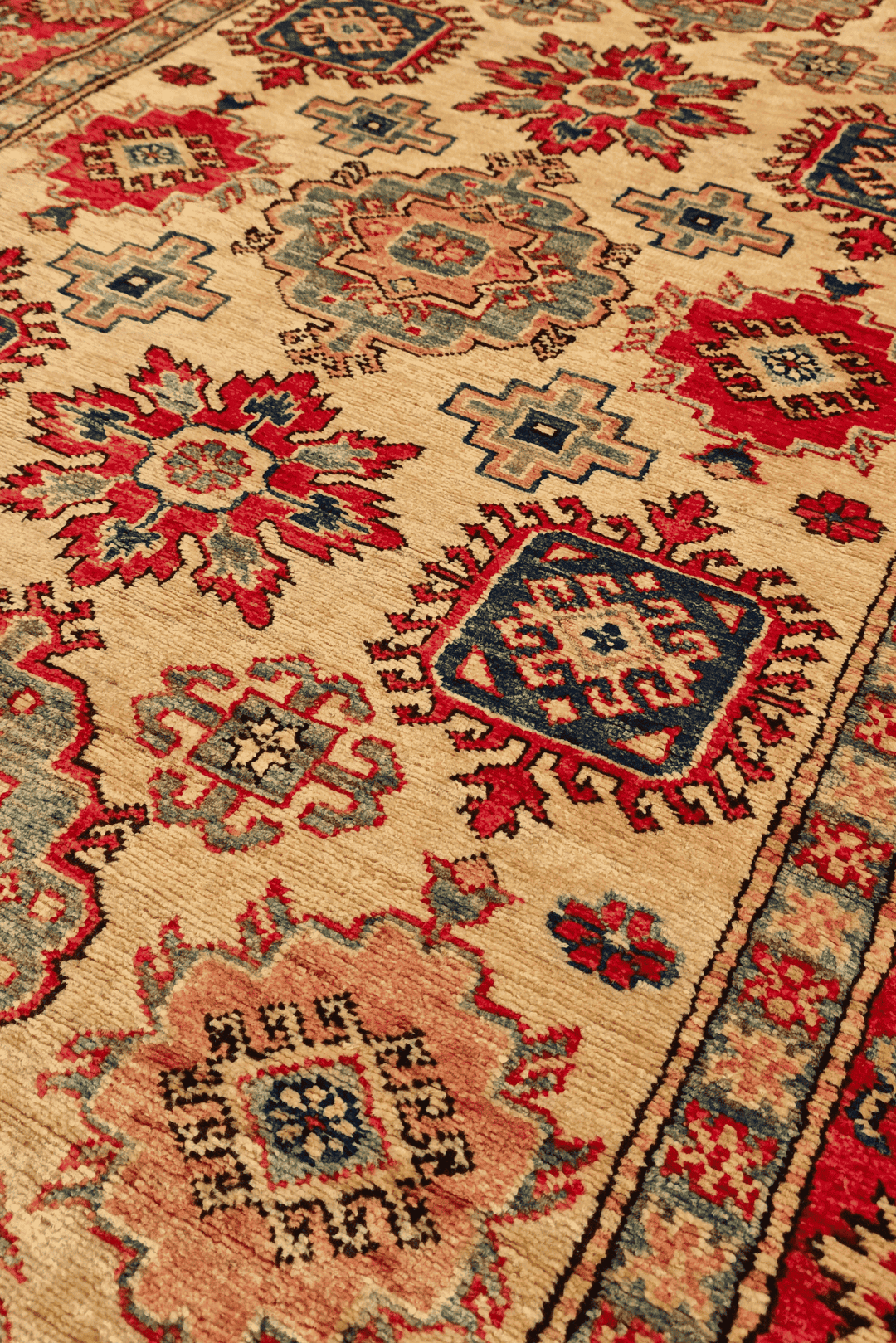 Sunburst medallion detail in gold and red on Afghan Sherwan rug