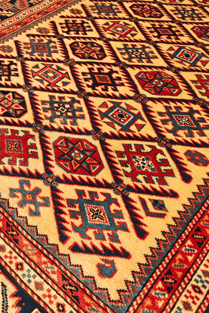 Border detail of gold and red Shirvan hand-knotted Afghan rug