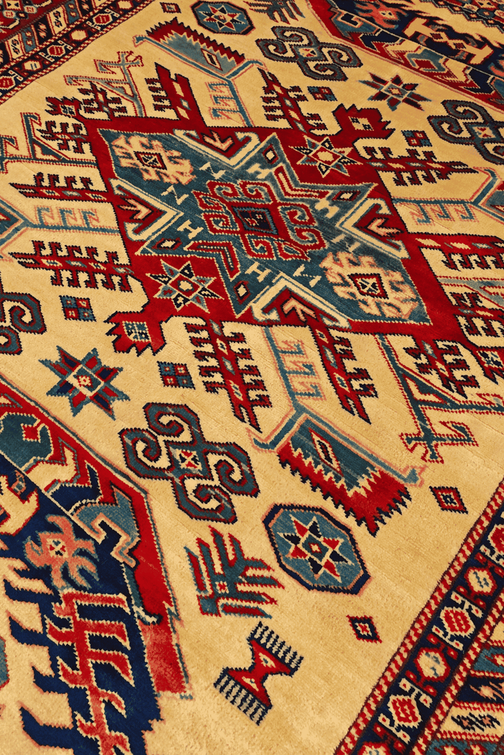 Border detail of ivory and red sunburst hand-knotted Afghan rug