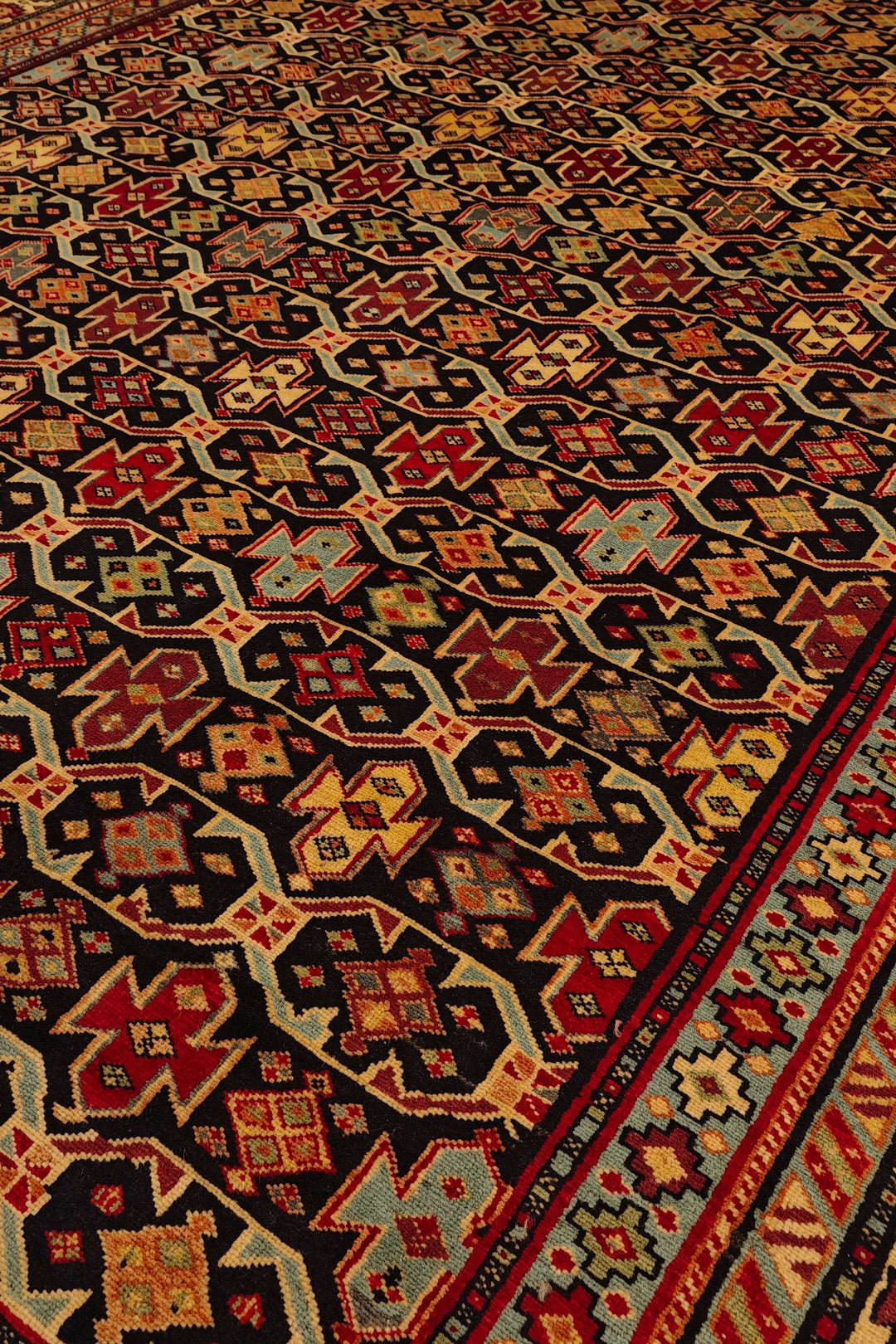 Hand-knotted wool pile of red Chi-Chi Afghan Sherwan rug