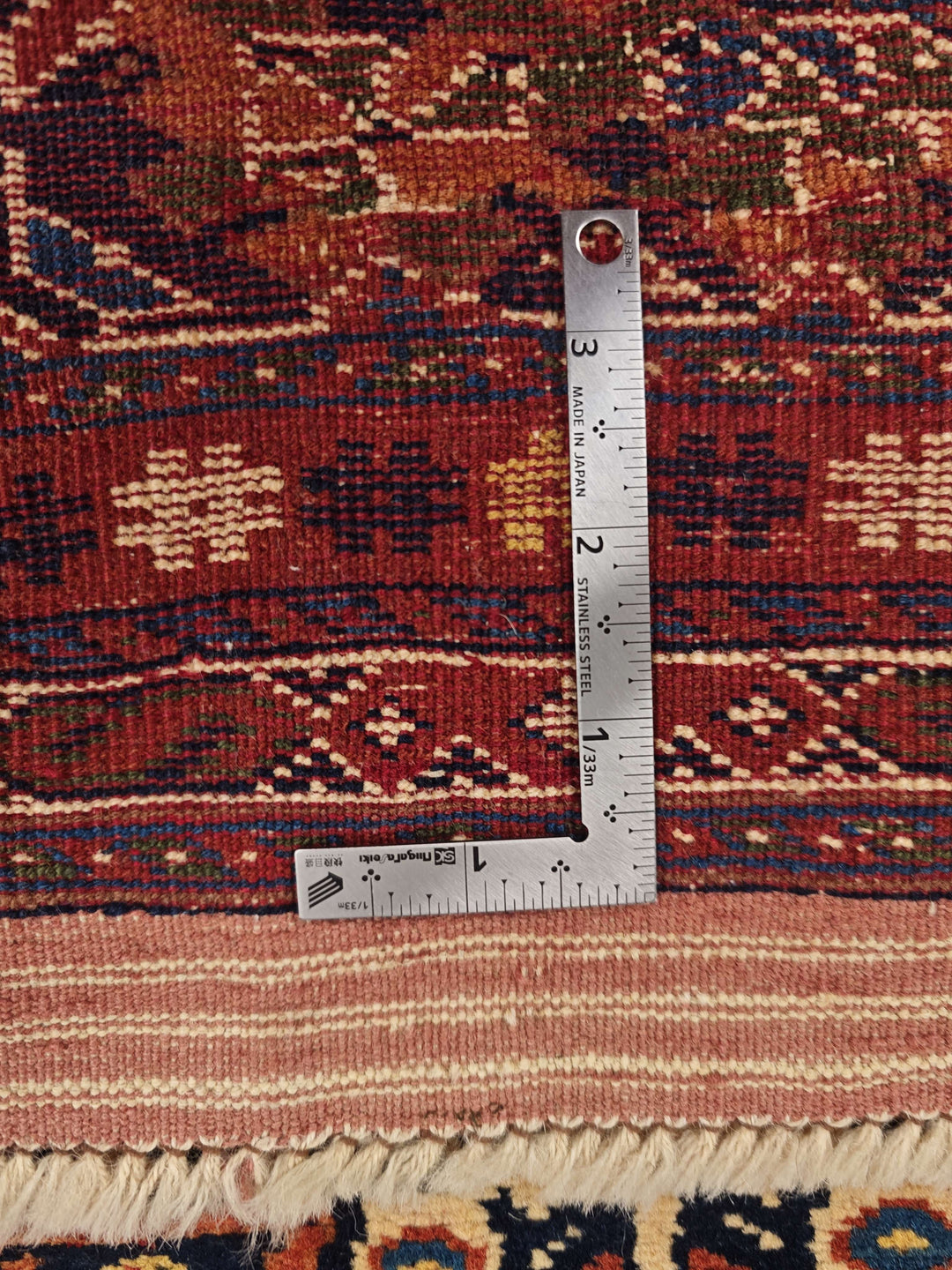 Corner of navy and red Yalameh Afghan hand-knotted rug