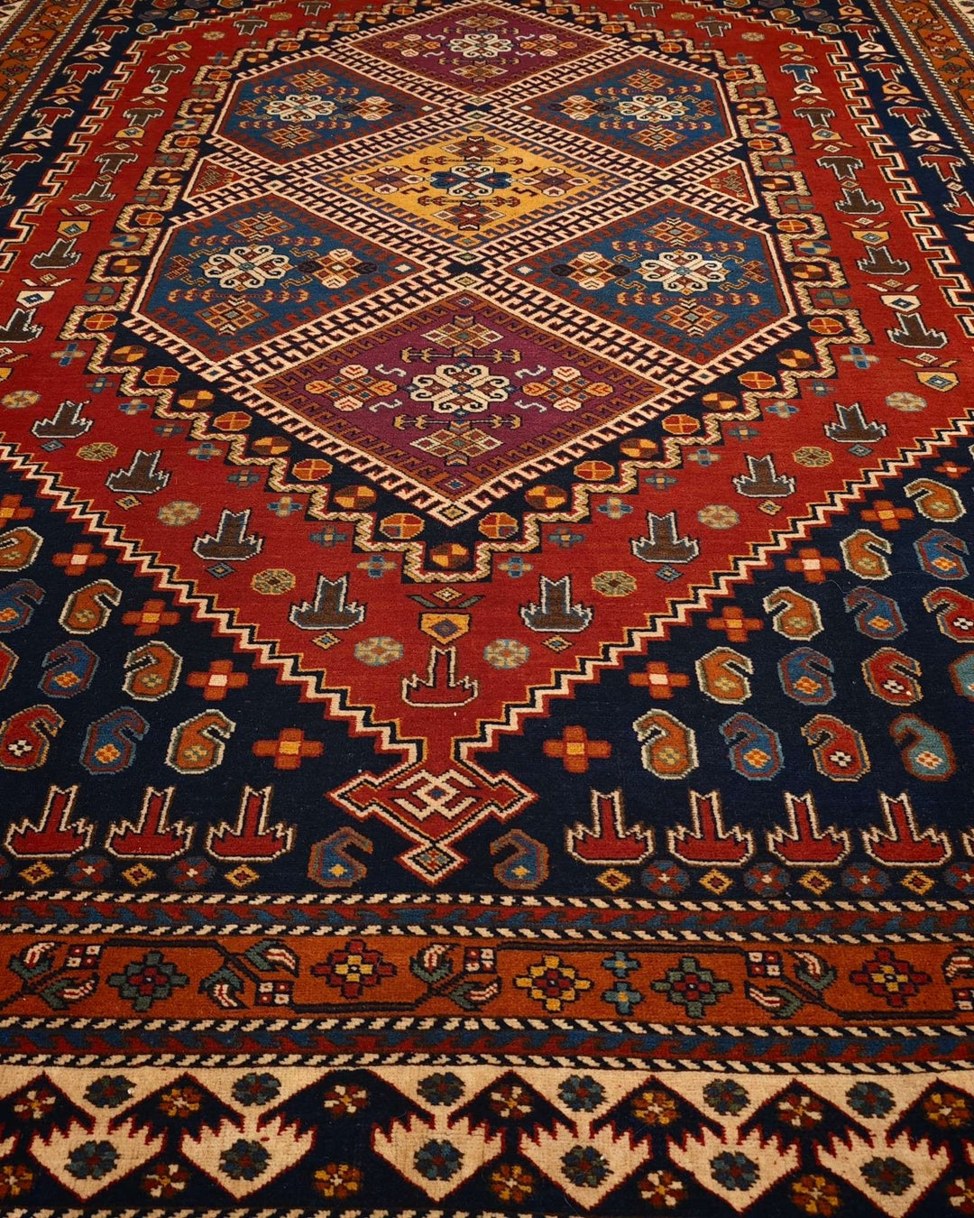 Border detail of navy and red tribal hand-knotted Afghan rug