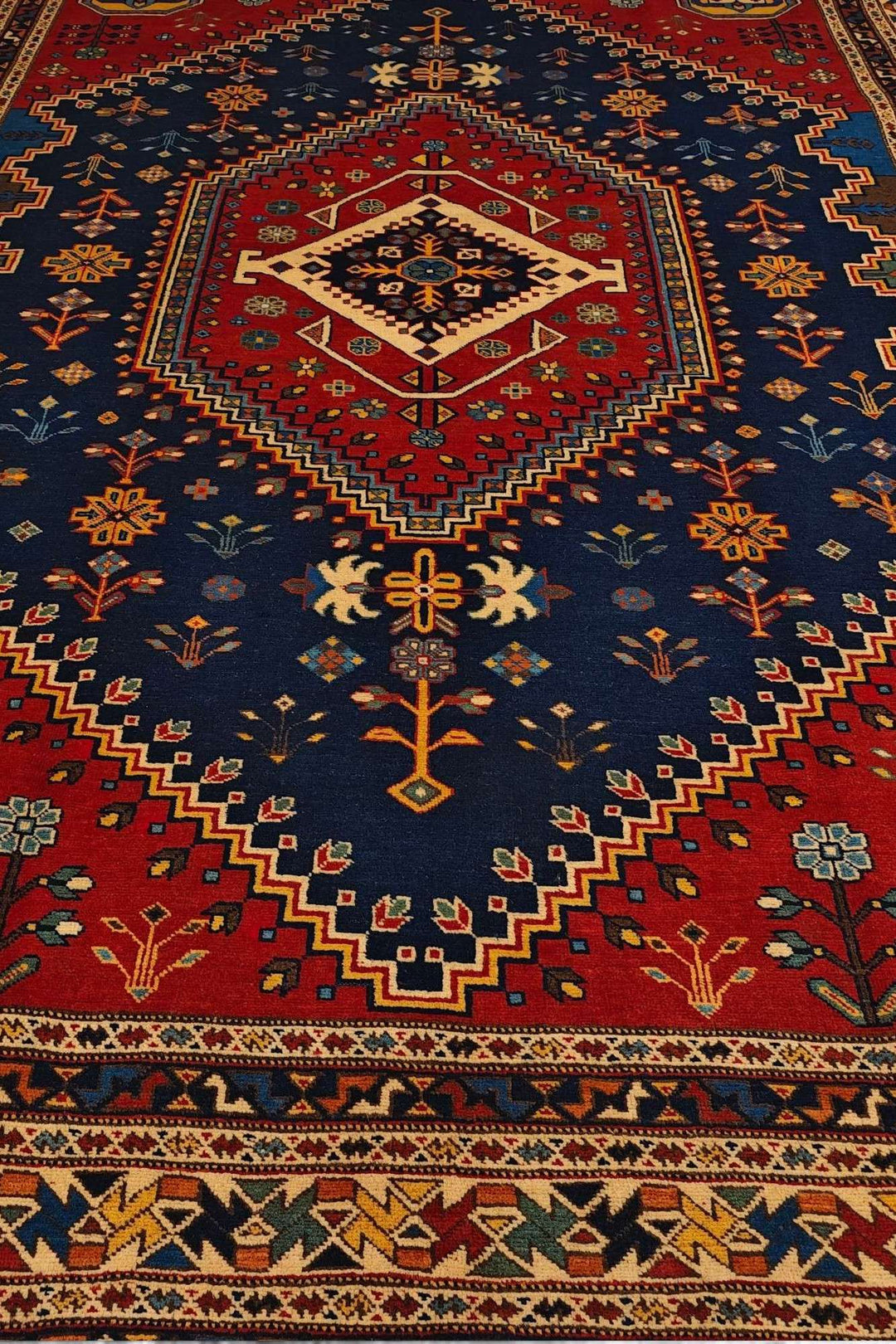 Border detail of navy and red Shiraz hand-knotted Afghan rug