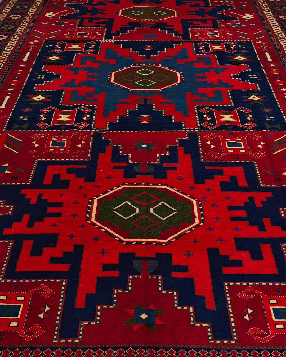 Border detail of red and navy Lesghi hand-knotted Afghan rug