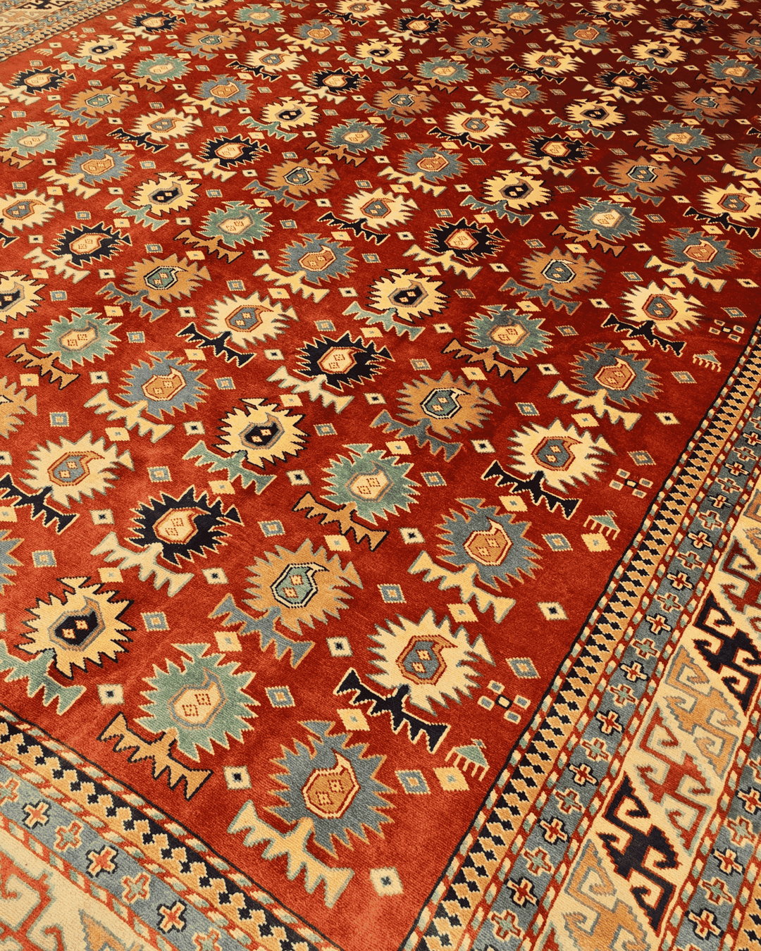 Border detail of red medallion hand-knotted Afghan rug