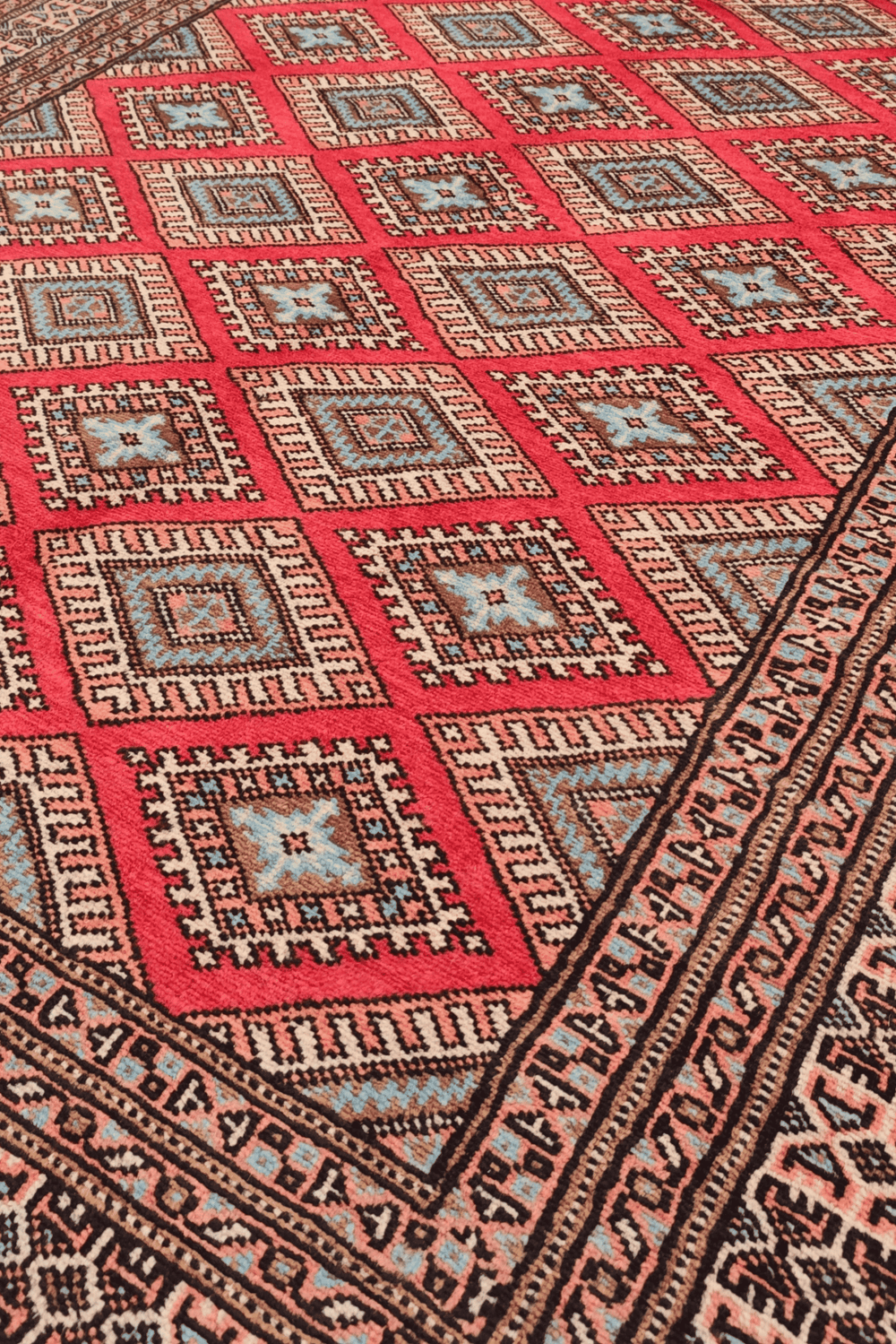 Diamond lattice detail in crimson and salmon on Pakistani rug