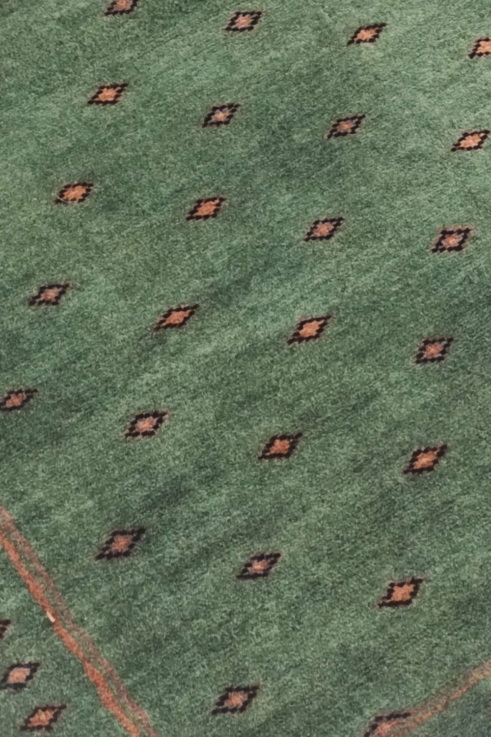 Dot-grid detail in sage green and brown on Pakistani rug