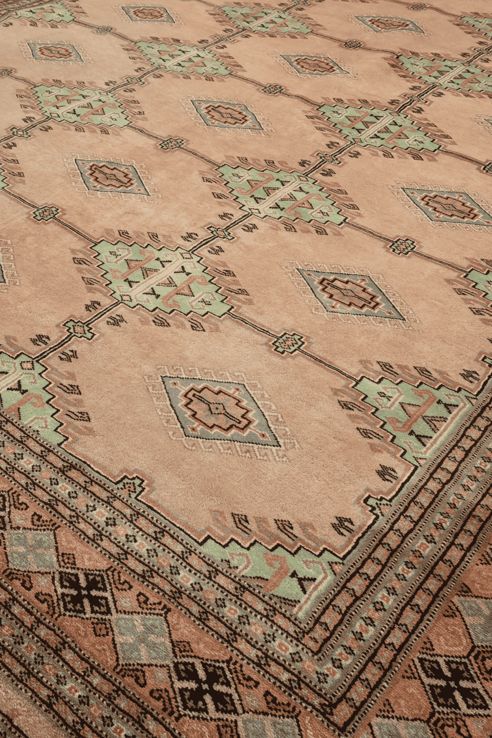 Alternating lattice detail in blush camel and sage on Pakistani rug