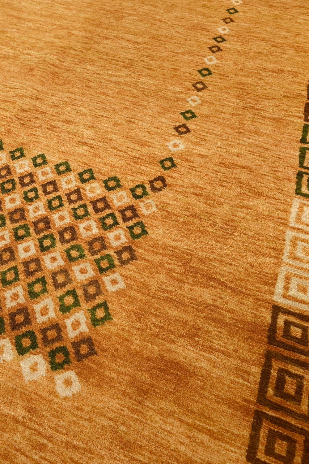 Diamond frame detail in amber and brown on Loribaf rug