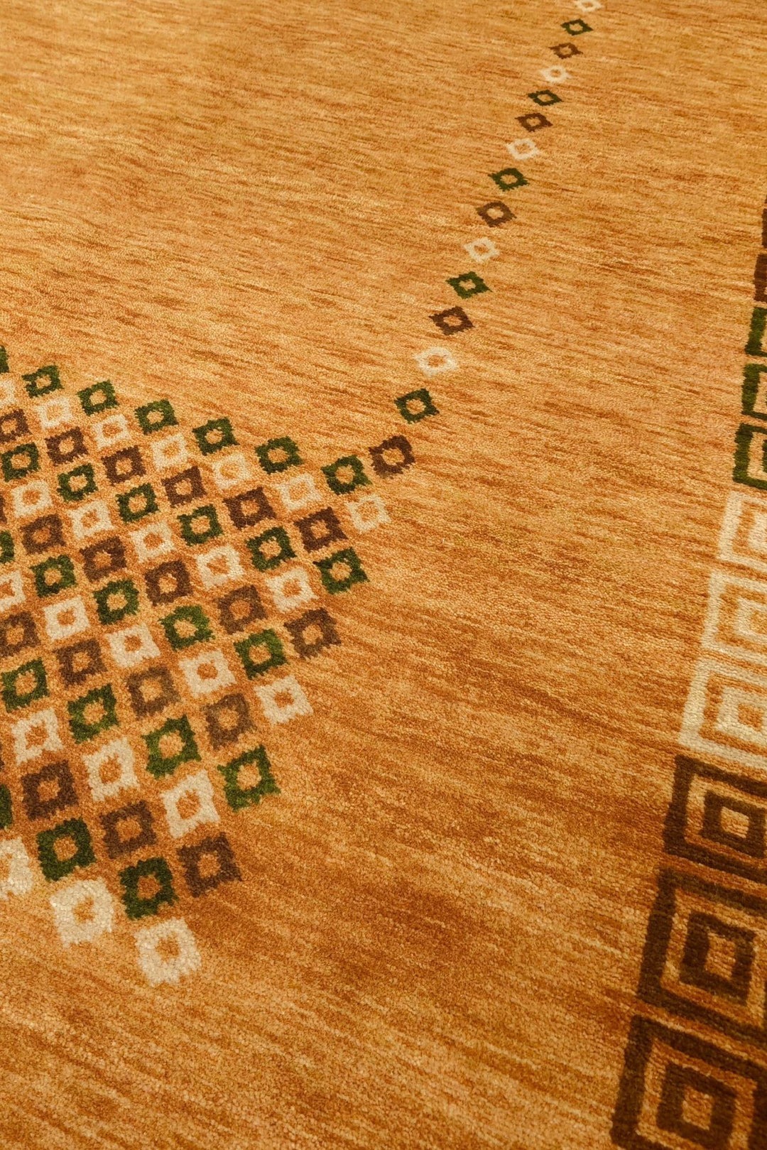 Diamond frame detail in amber and brown on Loribaf rug