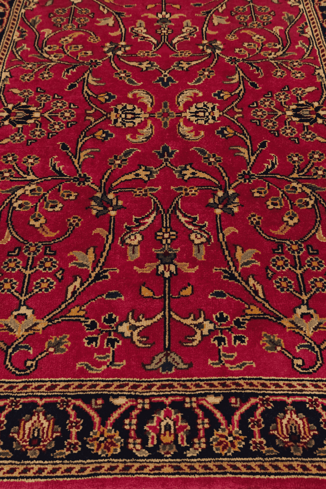 Corner of crimson Sarouk hand-knotted Indian rug
