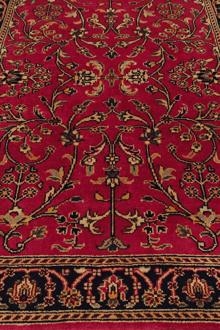 Corner of crimson Sarouk hand-knotted Indian rug