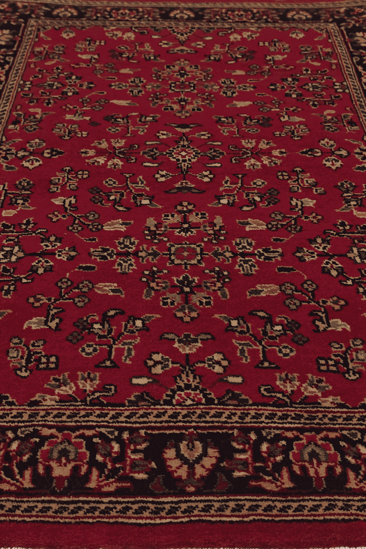 Corner of madder red Sarouk hand-knotted Indian rug